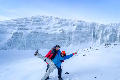 Trekkers below the ice cliffs of Kilimanjaro's summit glaciers