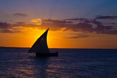 The silhouette of a dhow's sail as the sun drops into the Indian Ocean